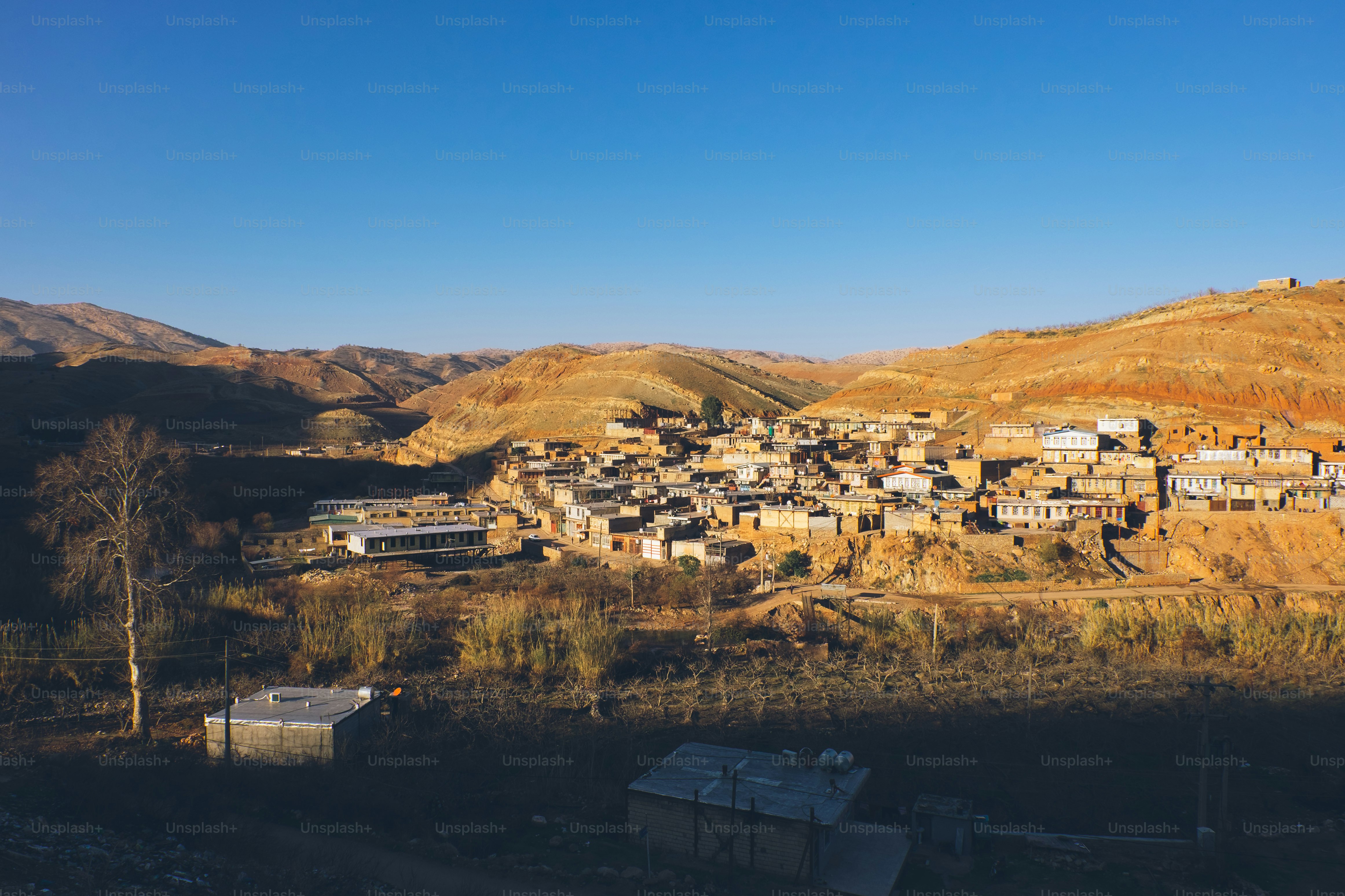 A village nestled in a valley with rolling hills
